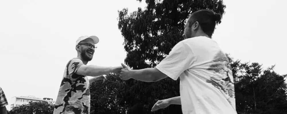 Zwei Tänzer:innen beim Hustle geben sich die Hand
